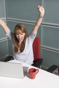 woman cheering at desk